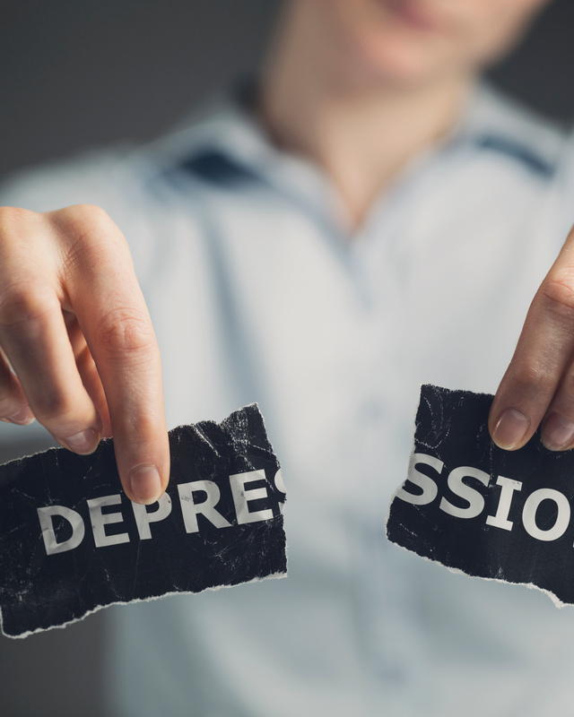 Person sitting alone while experiencing depression, exhaustion, and emotional heaviness